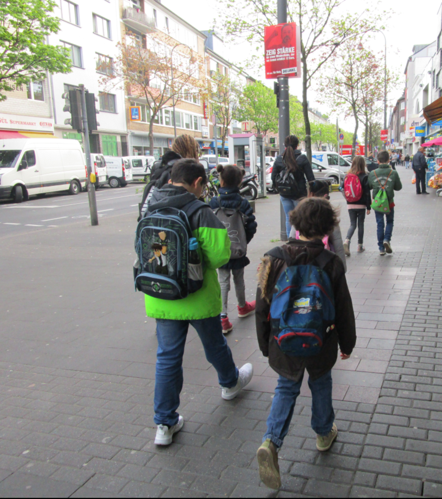 Kinder laufen im Rahmen der KinderUni durch Köln und untersuchen Mehrsprachigkeit im Alltag